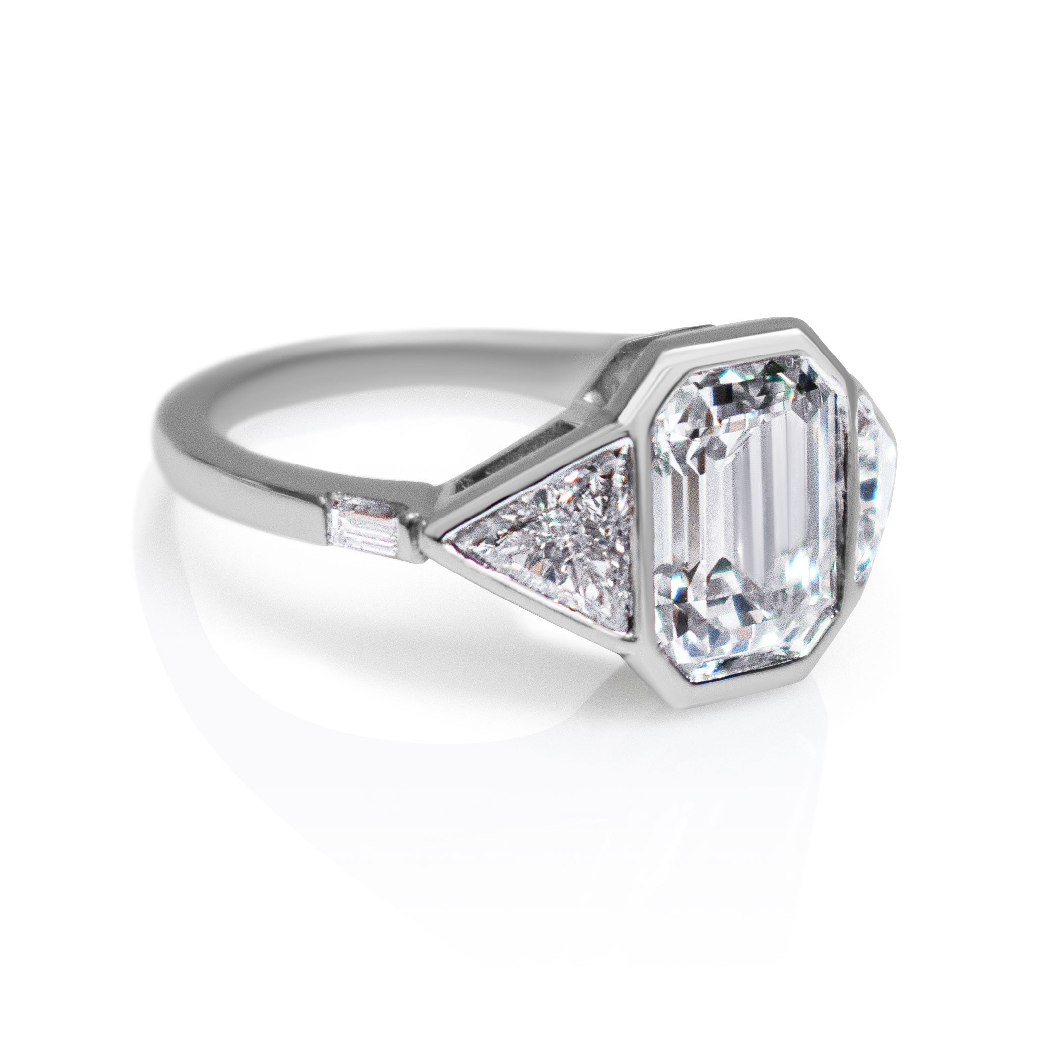 Emerald-cut diamond and triangular diamond engagement ring. Serena Ansell bespoke engagement ring design. Serena Ansell bespoke jewellery design. Bespoke engagement ring designer London. 